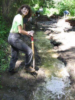 volunteer digs drainage ditch