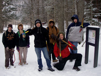 tool wielding people in snowy woods