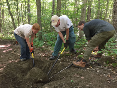 volunteers move boulder